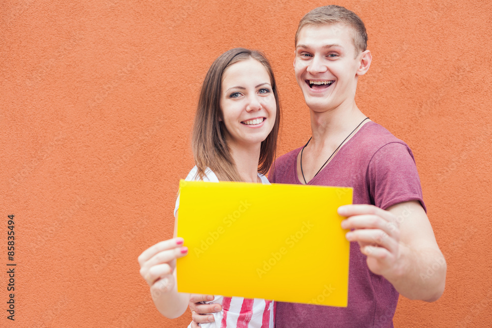 Happy people looking and holding frame at red background Happy people looking and holding frame at red background