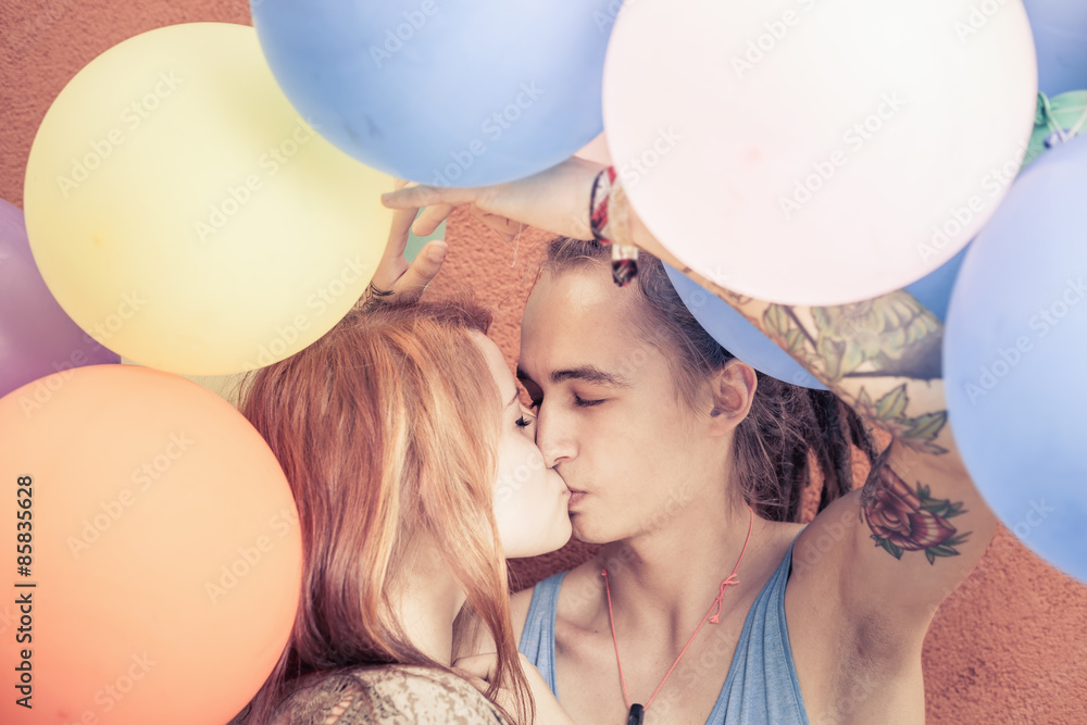 Closeup funny young couple kissing at background of color balloons. They  celebrate a happy birthday or summer holiday! Like an International, World  Kissing Day 6 July or Valentine's Day Stock Photo |