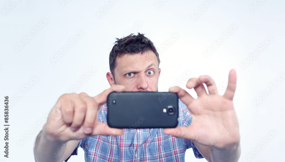 Bearded man photographed by smartphone