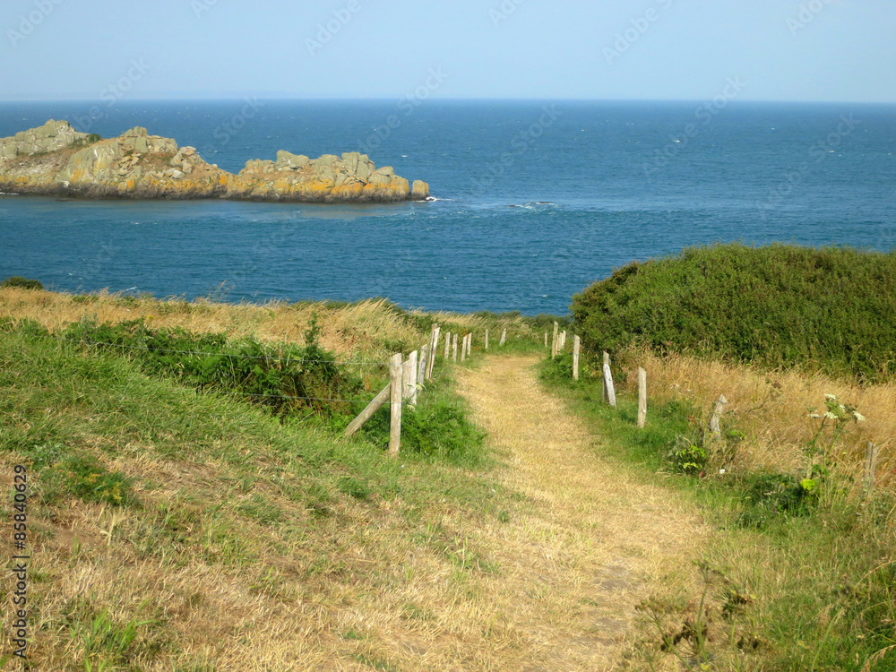 Road to the ocean with rocks. Brittany, France