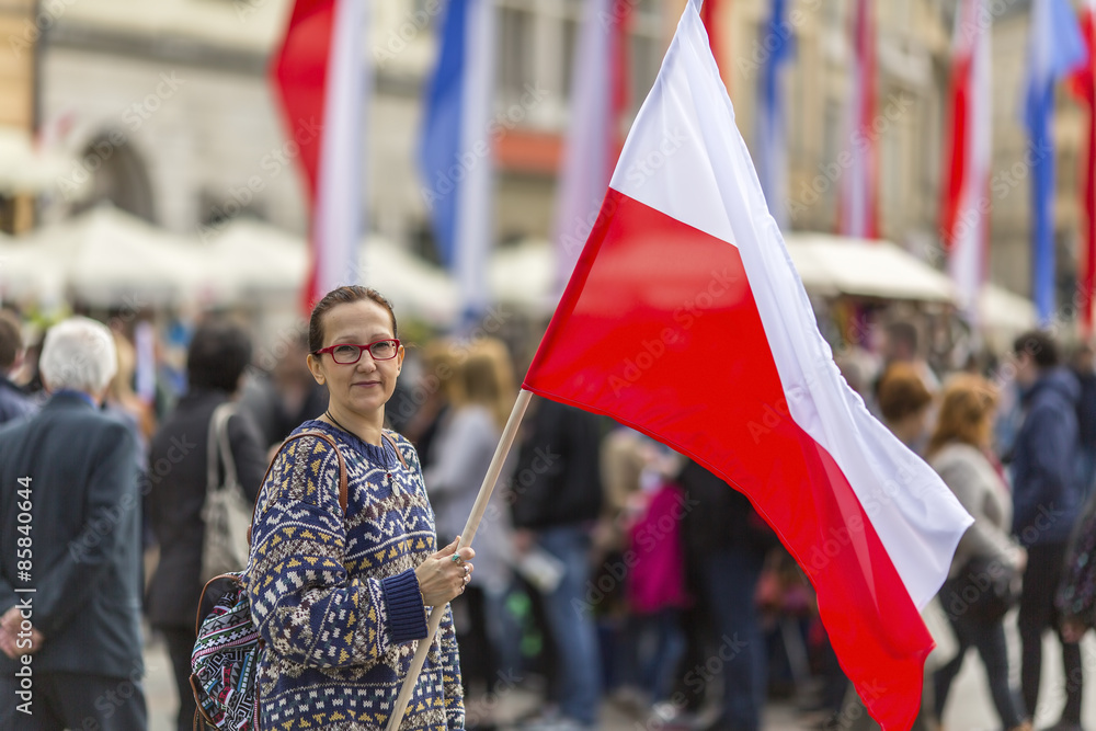 Woman on the street holding a flag of the Republic of Poland. - obrazy, fototapety, plakaty 