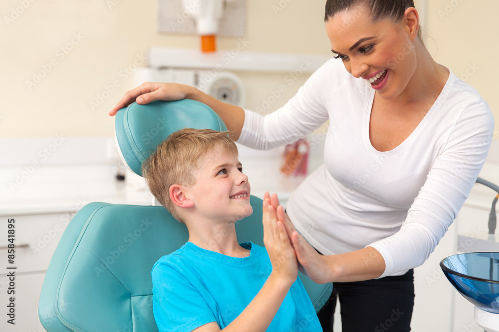 little boy and mother high five in dentist office little boy and mother high five in dentist office