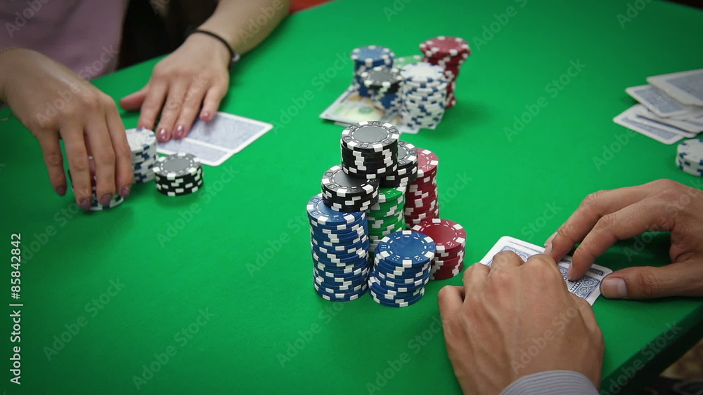 poker player with playing cards and chips at green casino table