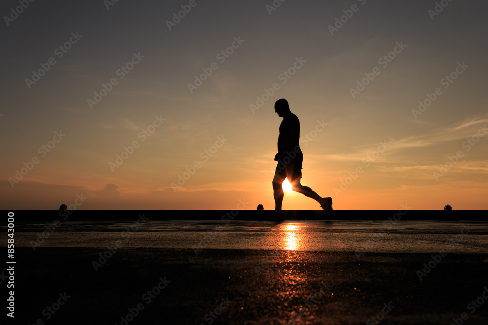 Silhouette Image of man walking on the helideck in the evening