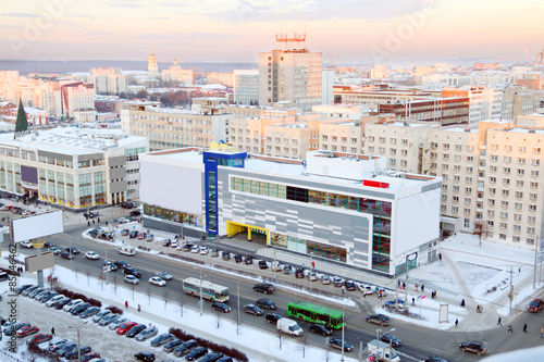 Shopping center next to road and parking in city in winter 