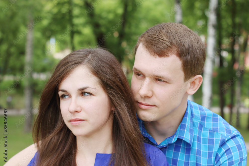 Young beautiful amn and woman looks away and dream in summer par Young beautiful amn and woman looks away and dream in summer par