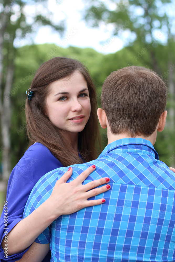 Happy woman and young man sit on bench and woman looks at camera Happy woman and young man sit on bench and woman looks at camera