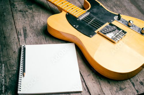 Telecaster electric guitar with notepad on wood desk