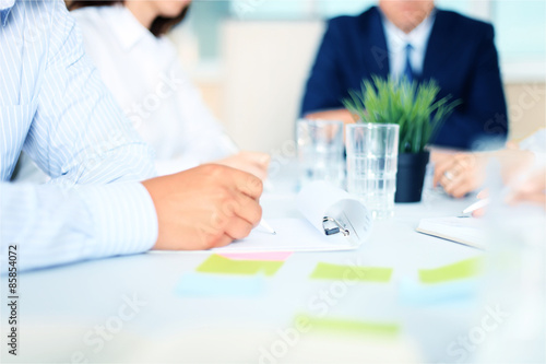 Business people sitting together and making notes at workplace