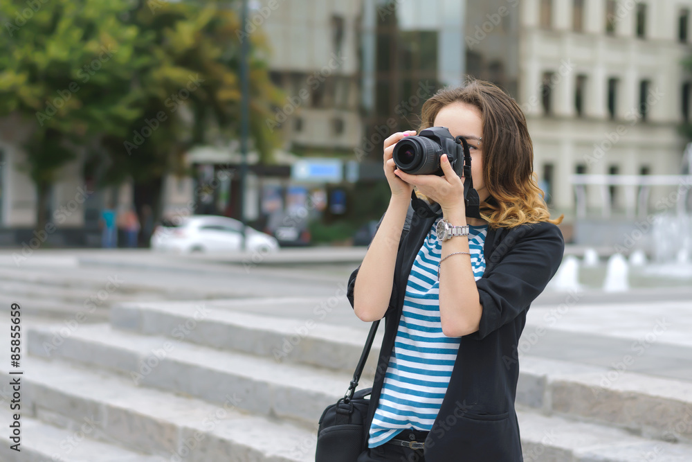 Woman with a camera photographs the city