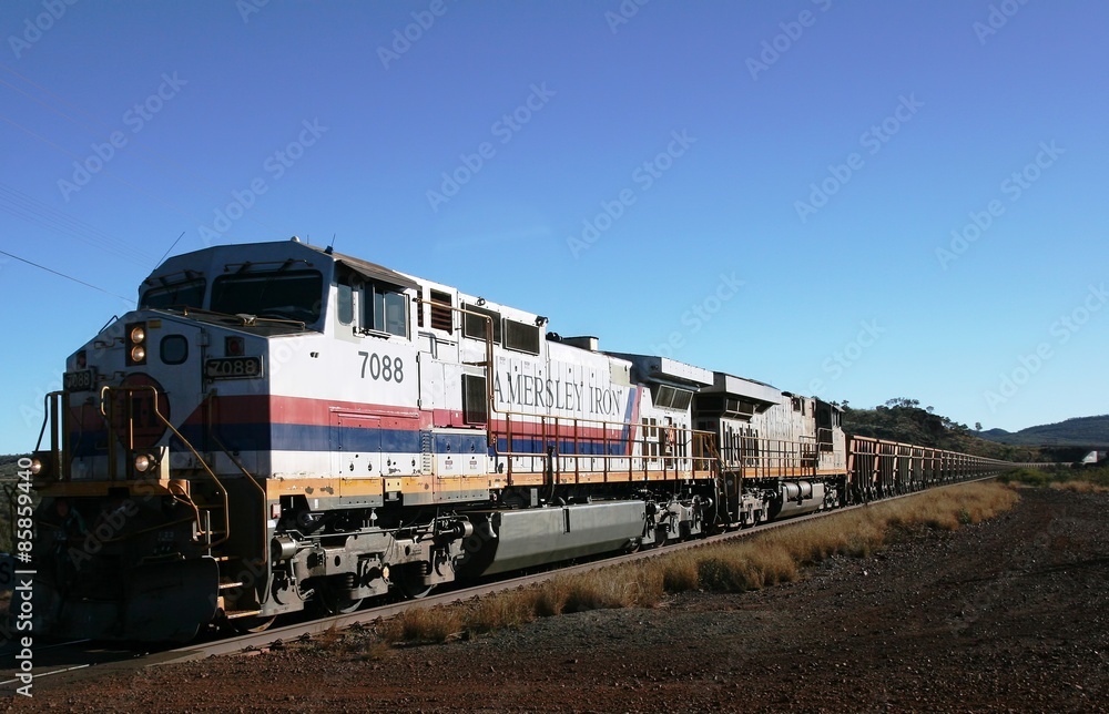 Fototapeta premium Tom Price, Australia - 2008, July 4: Hamersley Rio Tinto Iron ore train with two front engines on its way from Mount Tom Price mine at Tom Price in the Pilbara region of Western Australia