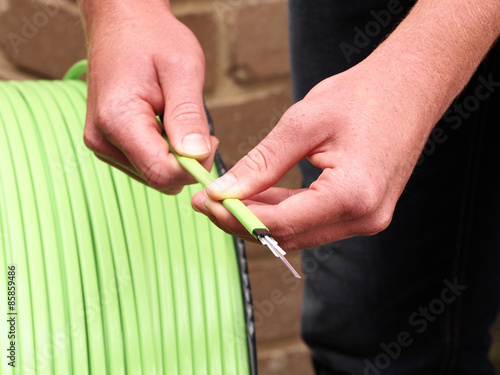 Green Nylon jacketed12 fiber optic ribbon cable with stripped end reeled of a small cable spool used for the National Broadband Network in Australia, a fast internet rollout covering 90% of Australia.