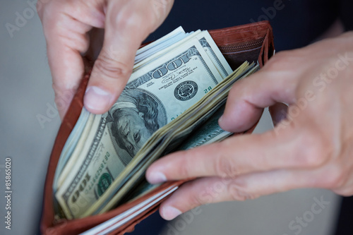 man holding a purse with money closeup