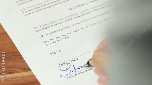 Partnership Agreement - Over the shoulder shot of a general partnership agreement being signed by both parties