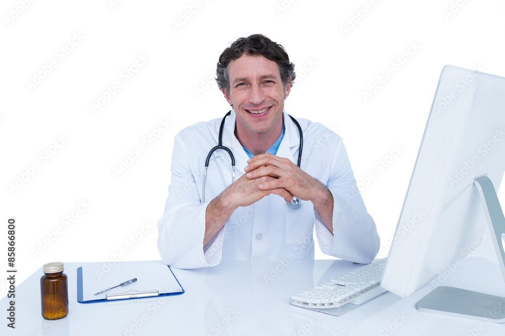 Smiling doctor working on his laptop Smiling doctor working on his laptop