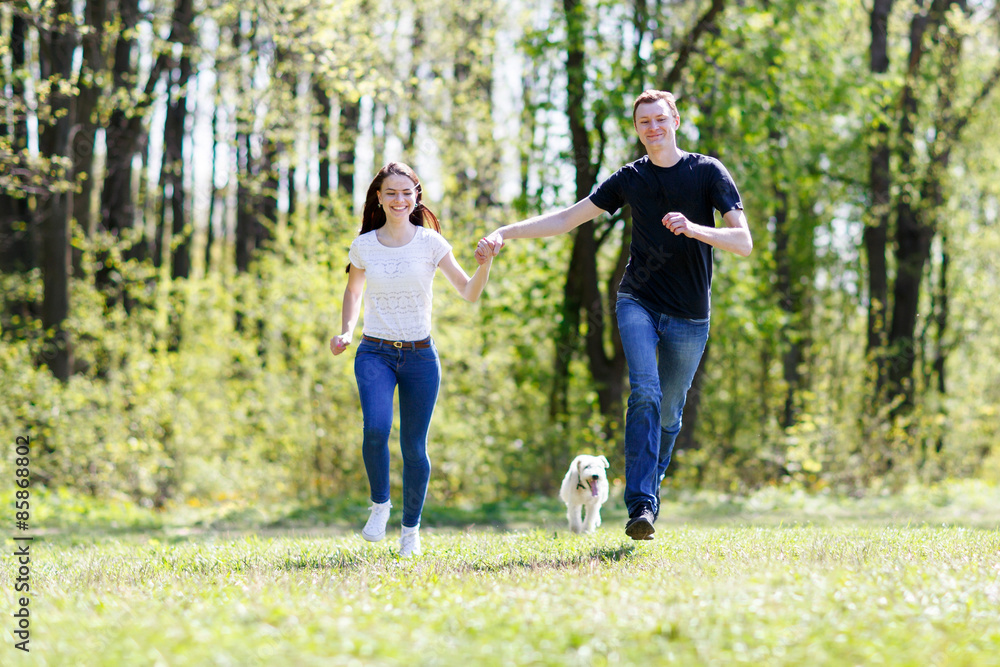 Obraz premium Happy young couple and dog