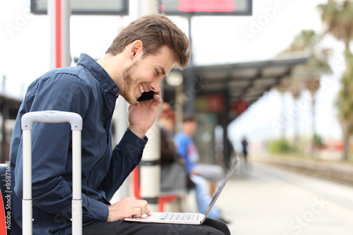 Freelancer working with a laptop and phone in a train station