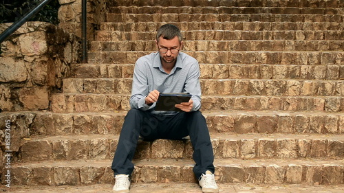 Student using on tablet on the stairs