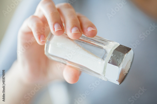 close up of hand holding white salt cellar photo