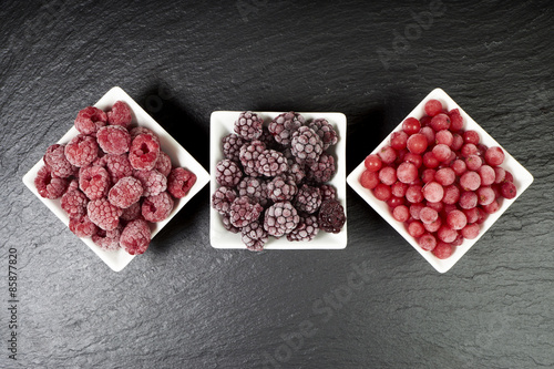 Drei Sorten gefrorene Beerenfrüchte in Porzellanschalen