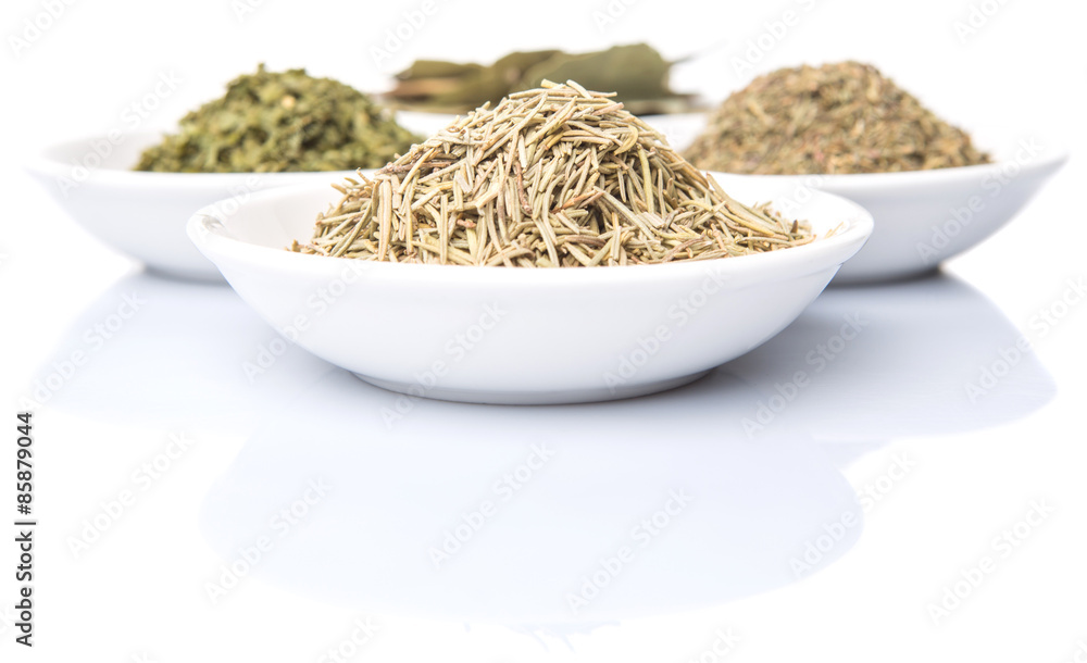 Rosemary, parsley, bay leaves and thyme in white bowl over white background Rosemary, parsley, bay leaves and thyme in white bowl over white background