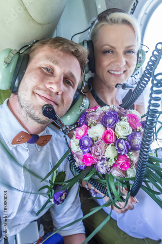 happy wedding couple bride and groom riding helicopter photo