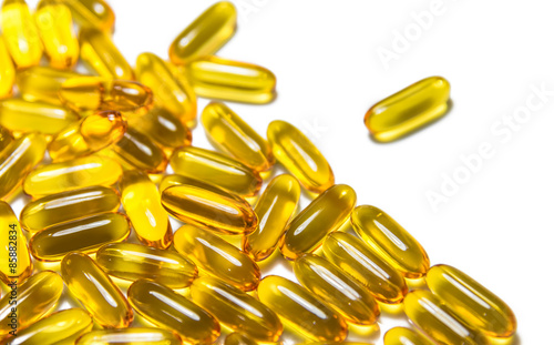 Piles of fish oil capsules isolated on white