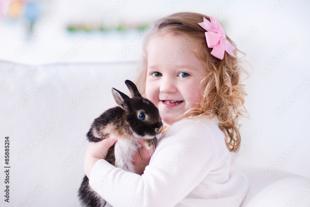Little girl playing with a real pet rabbit Little girl playing with a real pet rabbit
