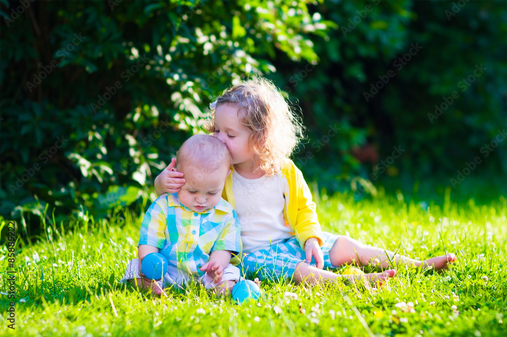 Happy children playing in the garden with toy balls Happy children playing in the garden with toy balls