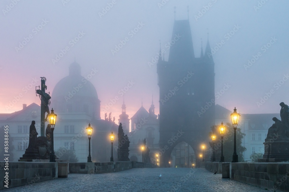 Charles Bridge in Prague at sunrise at morning in fog