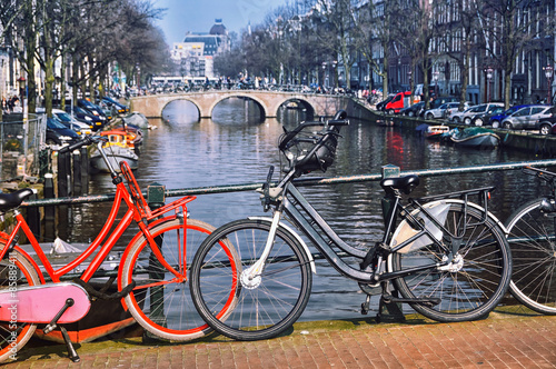 Canvas Print Typical city bicycles in Amsterdam at the bridge
