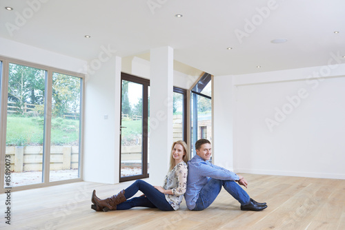 Happy Young Couple Sitting On Floor In New Home