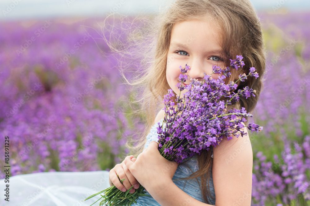 Happy little girl in lavender field with bouquet - obrazy, fototapety, plakaty 