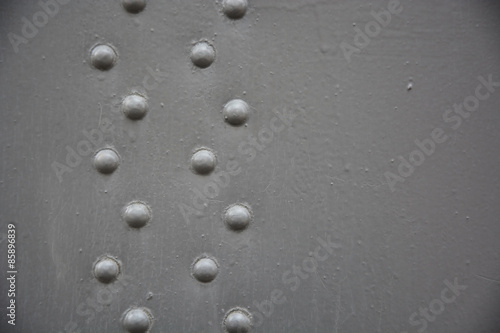 Grey metal background with rivets. Closeup view