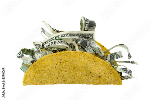 Shredded Money Taco Concept – A crispy taco shell filled with shredded money. Concept for the price of food, expensive eating, and more. Isolated on white with clipping path.