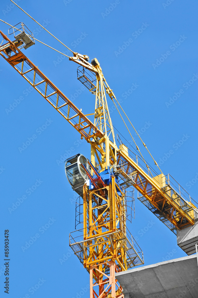 Crane and building construction site against blue sky Crane and building construction site against blue sky