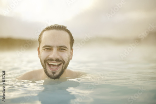 Sunny portrait of smiling young man in the pool of Blue Lagoon in Iceland © kegfire