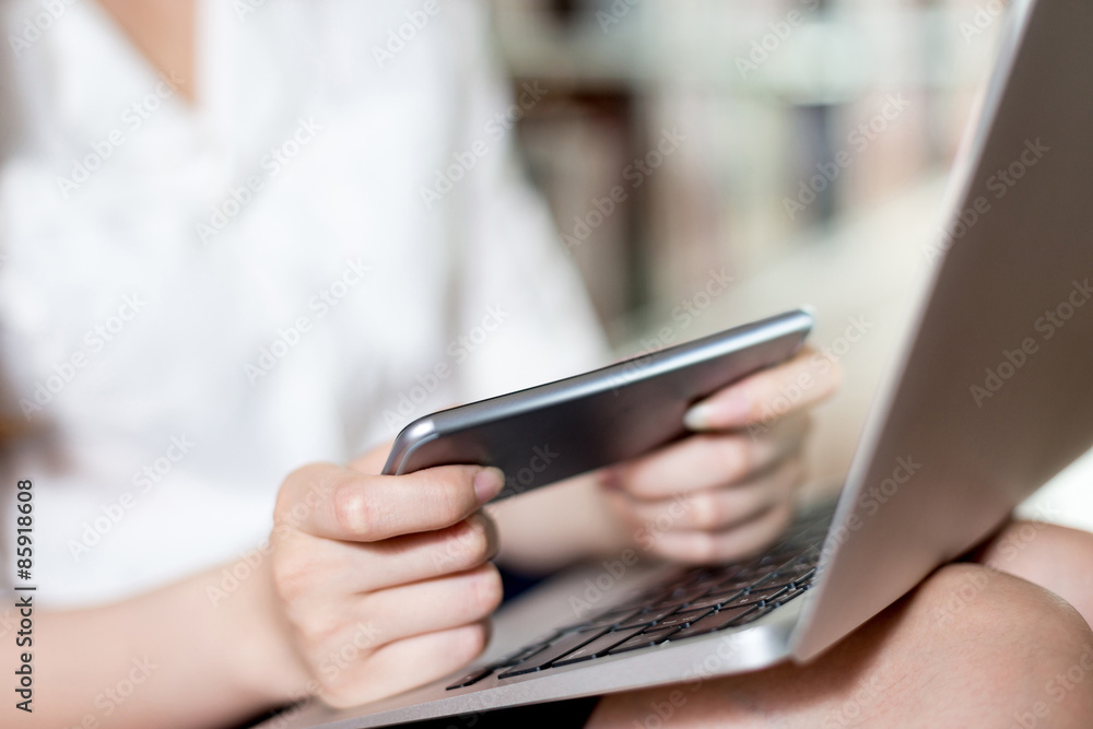 Asian beautiful female student studying in library with laptop