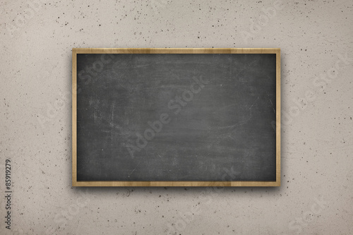 Black blank blackboard with wooden frame on concrete wall