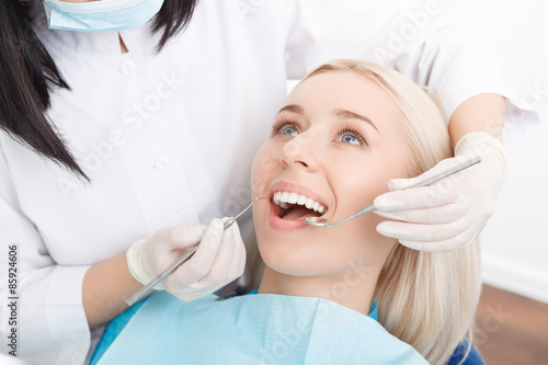 Woman having her teeth examined by dentist 