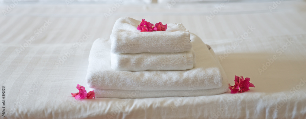 Frische Handtücher im Hotel, geschmückt mit Blüten Frische Handtücher im Hotel, geschmückt mit Blüten