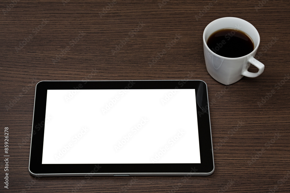 Top view on dark wooden office desk with modern digital tablet with blank screen and cup of coffee. Top view on dark wooden office desk with modern digital tablet with blank screen and cup of coffee.