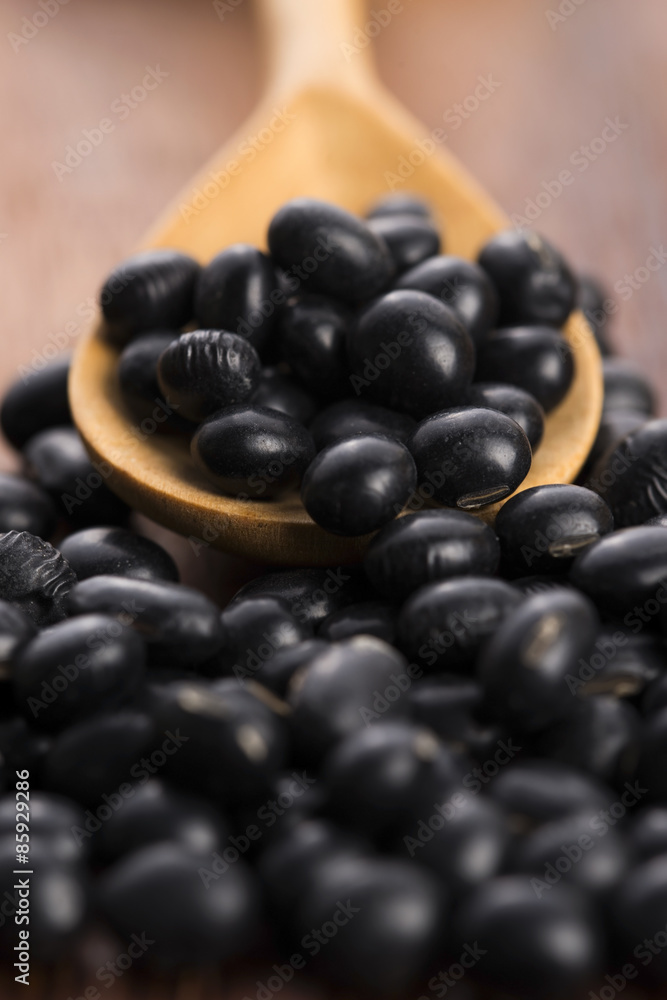 A lot of black soybeans on wooden background A lot of black soybeans on wooden background