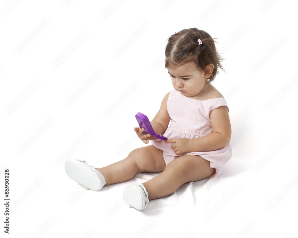 Baby girl in pink dress holding a toy phone Baby girl in pink dress holding a toy phone