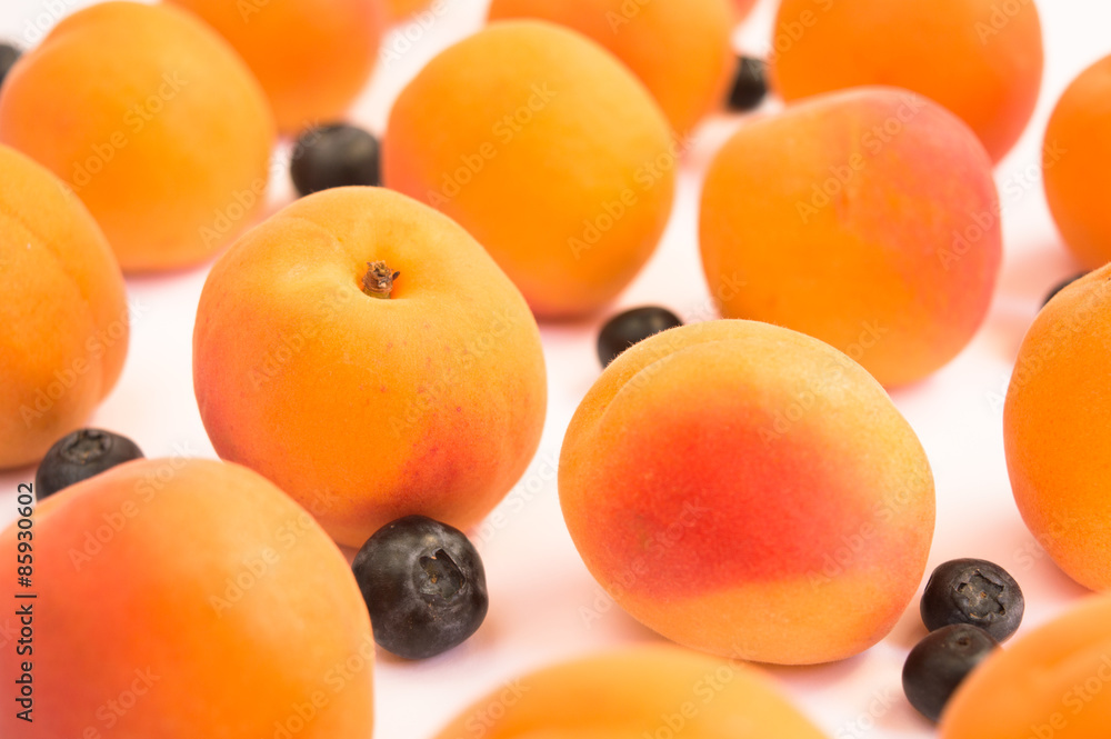 Ripe Fresh Apricots and Blueberries on a White Background Ripe Fresh Apricots and Blueberries on a White Background