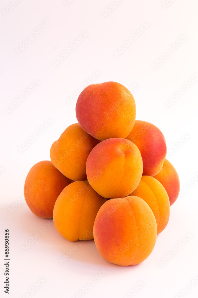 Pyramid of Fresh Ripe Apricots on a White Surface Pyramid of Fresh Ripe Apricots on a White Surface