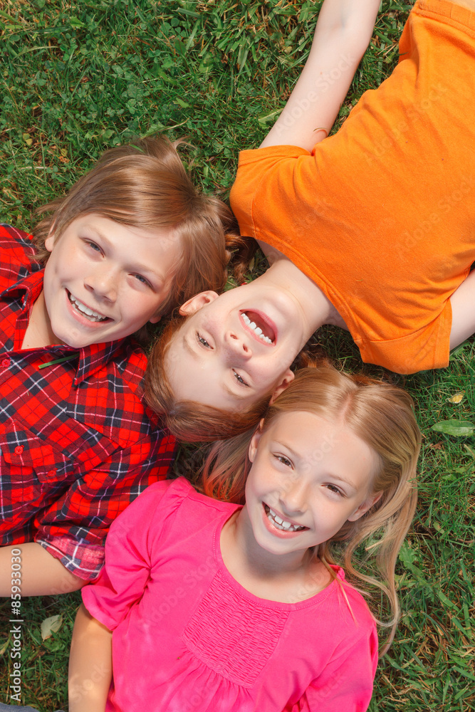 Fototapeta premium Top view of children lying on the groung 