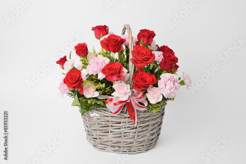 Fototapeta Naklejka Na Ścianę i Meble -  red roses and pink carnations in a basket