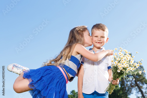 Pleasant little boy and girl kissing.  photo