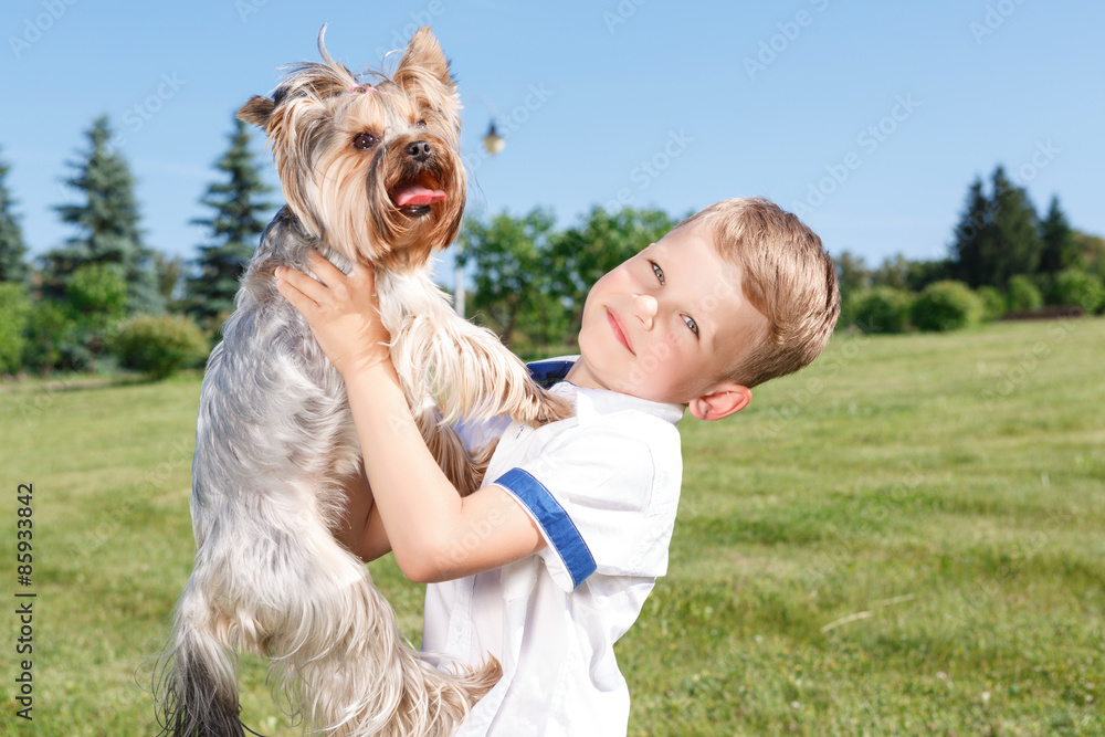 Pleasant little boy holding dog